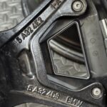 Close-up of a bicycle brake lever showing embossed numbers and a screw head on textured metal.