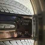 Close-up of tire tread pressed against the wheel well, showing detailed patterned rubber and a hint of the metallic rim edge.