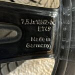 Close-up of a black bicycle frame showing stamped serial numbers and the words 'Made in Germany' on the metal surface.