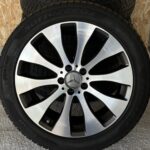 Close-up of a car wheel showing a polished silver multi-spoke alloy rim with a mounted tire.