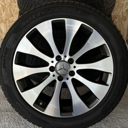 Close-up of a car wheel showing a polished silver multi-spoke alloy rim with a mounted tire.