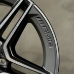 Close-up of a black, angular piece with a silver edge trim and textured grip, set against a neutral background.