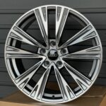 Close-up of a silver multi-spoke alloy car wheel resting on a cardboard box.