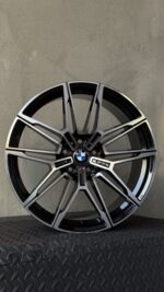 BMW alloy wheel with a multi-spoke design, silver and black finish, centered BMW logo and M badge visible