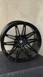 Black BMW alloy wheel with a complex multi-spoke design and center emblem.