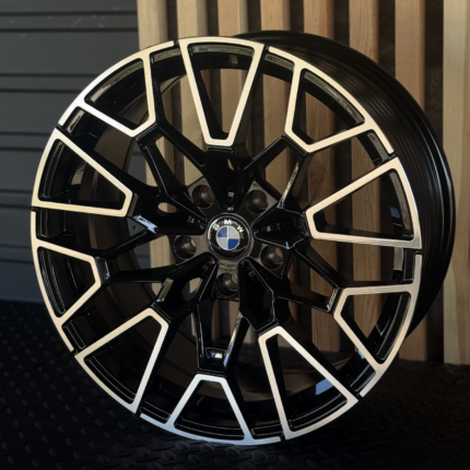 Black and silver BMW alloy wheel with an intricate geometric spoke design and a central BMW logo.