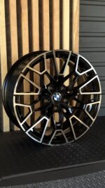 Close-up of a black and silver BMW alloy wheel with an intricate multi-spoke design and a blue-and-white BMW center cap.