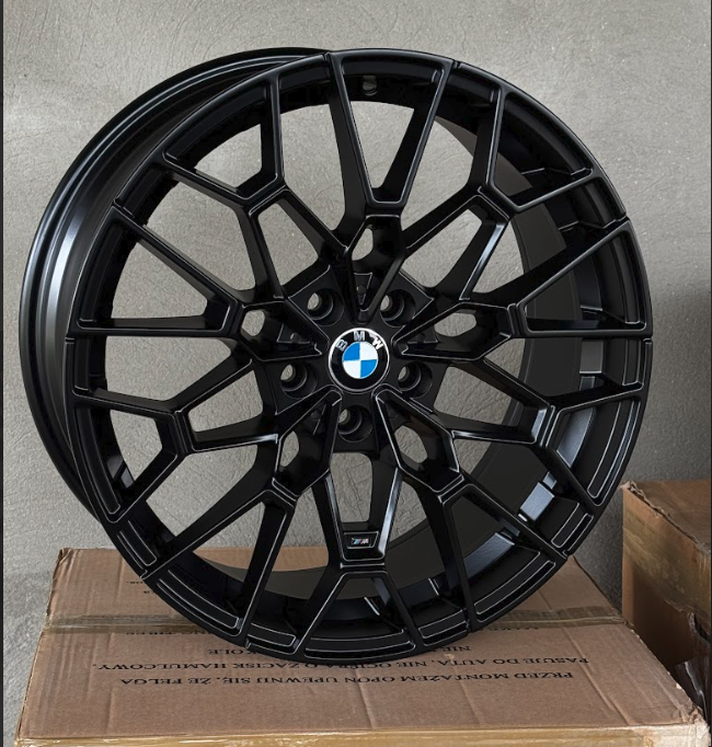 racingline_rfx-238_glossblack Black multi-spoke BMW alloy wheel with BMW roundel center, propped on a cardboard box.