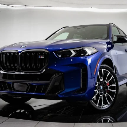 Blue BMW SUV (M badge) shown from a front three-quarter view with large kidney grille and sporty black wheels, on a showroom floor