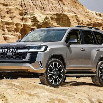 Silver Toyota SUV parked on sandy desert terrain with sandstone cliffs in the background