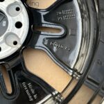 Black alloy car wheel rim with 'Made in Germany' and 'DC280 K2' markings, showing the hub area and bolt holes.