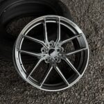 Chrome alloy wheel with a multi-spoke design resting on gravel surface