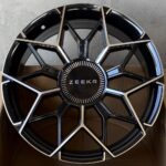 Black alloy car wheel rim with geometric silver spokes and a ZEEKR center cap.
