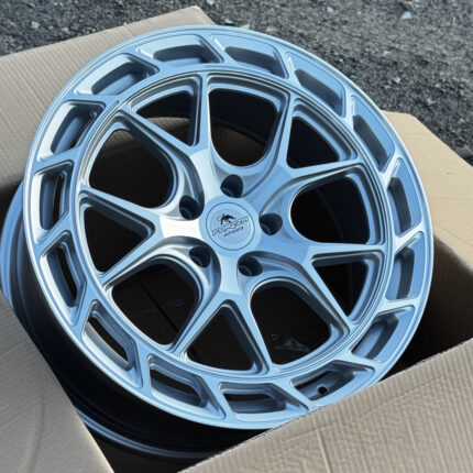 Silver multi-spoke alloy wheel with a Forza Wheels logo in the center, resting in a cardboard box.