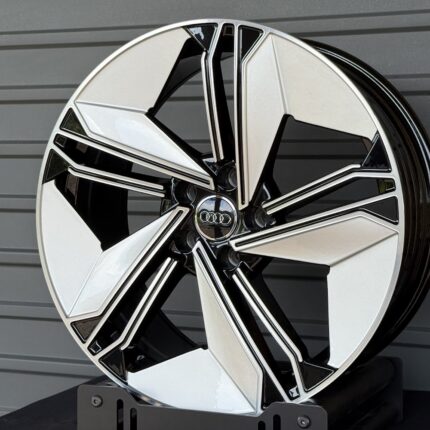 Close-up of a stylish alloy car wheel with a multi-spoke geometric design and an Audi center cap.