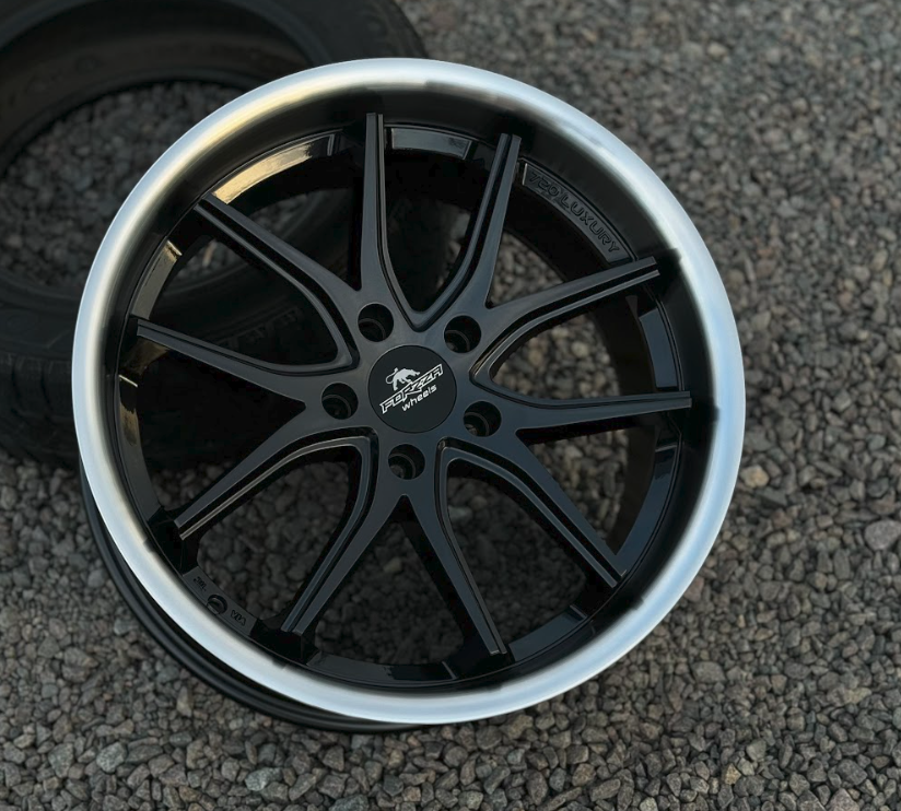 DSK-R19-5x120-89e1c1_0-2 Black multi-spoke forged alloy wheel with a silver lip on a gravel surface, center cap reads Forged Wheels.