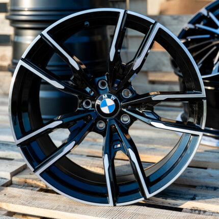 Close-up of a glossy black and silver BMW alloy wheel with the BMW emblem at the center.