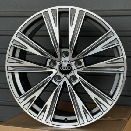 Audi alloy wheel rim with a multi-spoke design and central logo resting on a box