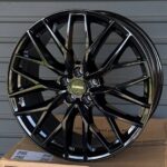 Close-up of a glossy black multi-spoke alloy wheel with chrome accents and a central RL WHEELS cap.
