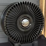Close-up of a black turbine-style wheel with many spokes and a Range Rover center cap